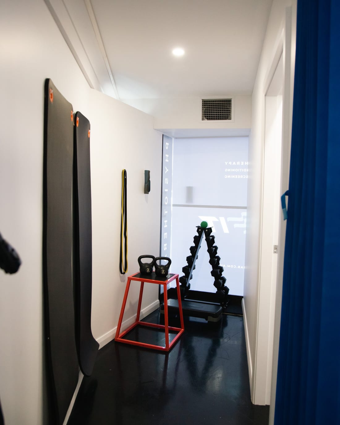 A rehab area with light kettlebells, mats and resistance bands